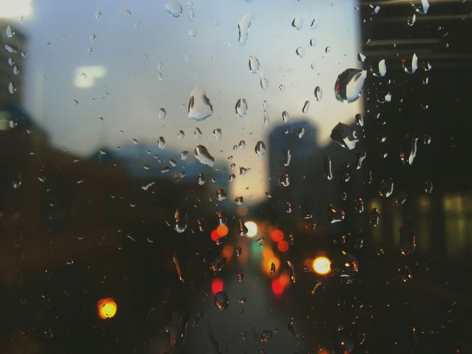 Street lights through a window covered in raindrops